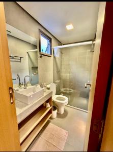 a bathroom with a sink and a toilet and a shower at Condomínio The Village Flecheiras in Flecheiras