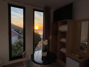 Habitación con mesa y ventana con puesta de sol. en four generation hotel en Shirokë