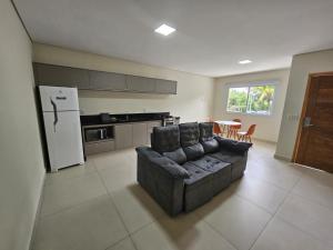 a living room with a couch and a kitchen at Vinhedo Plaza Hotel in Vinhedo