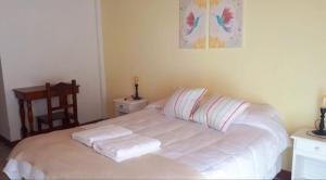 1 dormitorio con 1 cama con 2 toallas en avellaneda suites en Río Gallegos
