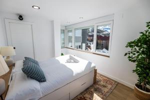 a white bedroom with a bed and a window at Luxury refurnished apartment with Private Parking close to ski slopes in Sierra Nevada