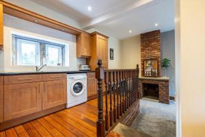 a kitchen with a washer and dryer and a fireplace at Countryside Getaway in Clayton West