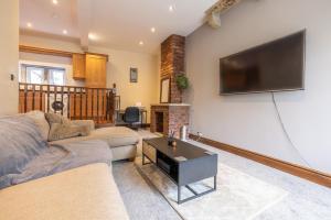 a living room with a flat screen tv on the wall at Countryside Getaway in Clayton West
