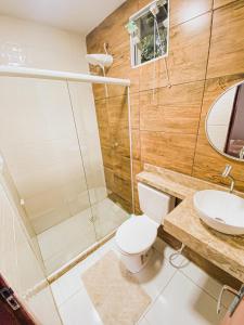 a bathroom with a shower and a toilet and a sink at Aruana Suites Tranquilidade e Sossego no meio da Natureza a 5km da Vila de Praia do forte in Praia do Forte