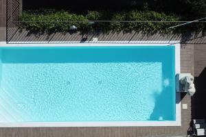 una gran piscina azul junto a un edificio en The Sunset Hill with Private Swimming pool and A/C, en Camaiore