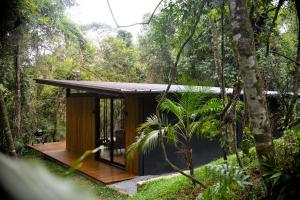 a house in the woods with a wooden deck at CHALÉ NAMATA 201 in São Roque