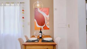 a dining room table with wine glasses and a painting at La Isolina Casa en Chacras de Coria in Chacras de Coria
