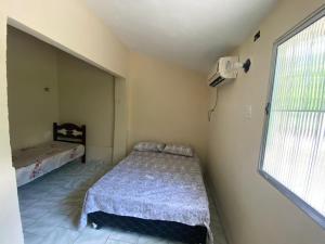 niewielka sypialnia z łóżkiem i oknem w obiekcie Rancho Cariri (São Jorge do Cariri) w mieście Bôca da Mata