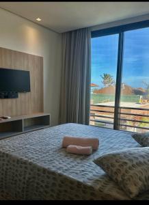 a bedroom with a bed with a view of a beach at Condomínio The Village Flecheiras in Flecheiras