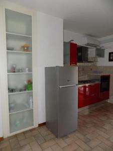 La cuisine est équipée d'un réfrigérateur en acier inoxydable et de placards rouges. dans l'établissement Marco Romani, à Pérouse