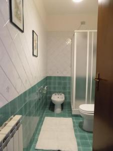 a green and white bathroom with a toilet and a shower at Marco Romani in Perugia