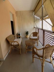 - une terrasse couverte avec des chaises et des chaises en osier sur un balcon dans l'établissement Marco Romani, à Pérouse
