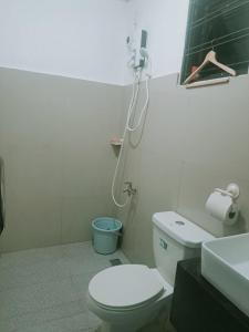 a bathroom with a white toilet and a sink at Hundred Islands lucky One Transient 3mins walk fr wharf in Alaminos