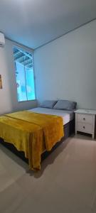 um quarto com uma cama com um cobertor amarelo em Palmas home rental em Palmas