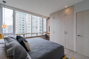 a bedroom with a bed and a large window at Beautiful Apt in Santa Fe with Panoramic Views! in Mexico City