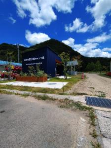 um edifício azul com um sinal na lateral em Ayu no Sato Park Campsite - Vacation STAY 42166v em Shōbara