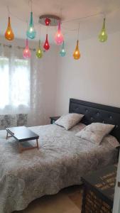 - une chambre dotée d'un lit avec des lumières colorées au-dessus dans l'établissement Paradis au soleil, à Alignan-du-Vent