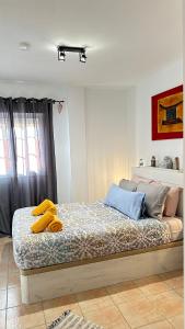 Un dormitorio con una cama con toallas amarillas. en Boutique Apartment Adeje I en Adeje
