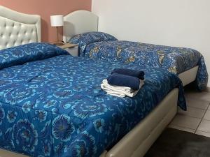 a bedroom with two beds with a blue comforter at B&B Martini Home 11 in Altamura