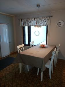 a dining room with a table and chairs and a window at Ainola 2 in Syöte