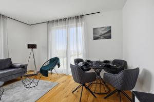 a living room with a table and chairs and a couch at PEAKview: Penthouse / Zentrum / Netflix in Limburg an der Lahn