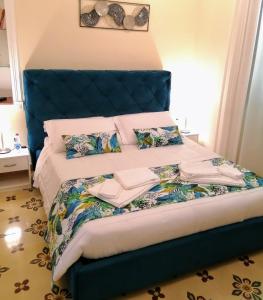 uma cama com cabeceira azul e almofadas em Suleima B&B Messina Centro em Messina