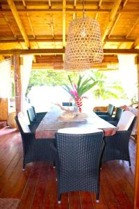 einen Esstisch mit Stühlen und einem Kronleuchter in der Unterkunft Villa Ruma Maria in Uturoa