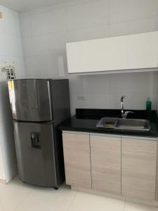 a kitchen with a stainless steel refrigerator and a sink at Apartamento Cerca Al Hotel Las Américas in Cartagena de Indias