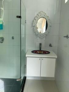 bagno bianco con lavandino e specchio di Apartamento Cerca Al Hotel Las Américas a Cartagena de Indias