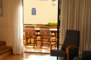 Habitación con sillas, mesa y balcón. en Villa Bahia Meloneras en Meloneras