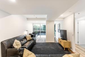 a living room with a couch and a television at City Fringe Crash Pad in Auckland