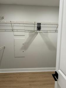 a room with a white wall with a shelf at Towson Elite Apartment in Towson