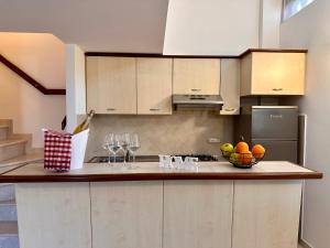 a kitchen with a bowl of fruit and wine glasses at Sperlonga Paradise Apartment Complex in Sperlonga