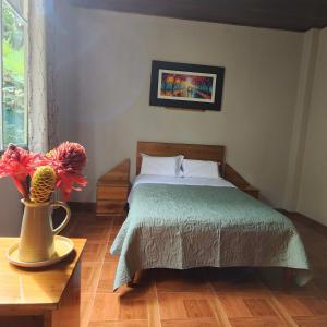 a bedroom with a bed and a vase with a flower at Casa Piamonte in Pichanaki