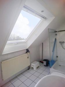 ein Bad im Dachgeschoss mit einem Dachfenster und einer Dusche in der Unterkunft Bad Homburg Wohnung für 5 Personen in Bad Homburg vor der Höhe