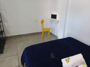 阿雷格里港的住宿－APARTAMENTO com SUITE DE CINEMA Prox Bourbon Ipiranga，一间卧室配有一张床和一张黄色椅子