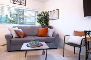 a living room with a couch and a table at Oasis Top Floor Suite with Lake and Mtn View in Harrison Hot Springs