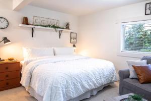 a bedroom with a bed and a clock on the wall at Oasis Top Floor Suite with Lake and Mtn View in Harrison Hot Springs