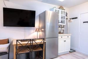 a stainless steel refrigerator in a kitchen with a table at Oasis Top Floor Suite with Lake and Mtn View in Harrison Hot Springs