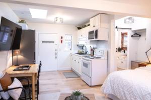 a kitchen with white appliances and a bed in a room at Oasis Top Floor Suite with Lake and Mtn View in Harrison Hot Springs