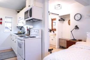a small kitchen with a stove top oven next to a bed at Oasis Top Floor Suite with Lake and Mtn View in Harrison Hot Springs