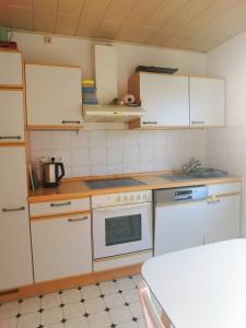 a kitchen with white cabinets and a stove top oven at Bad Homburg Wohnung für 5 Personen in Bad Homburg vor der Höhe