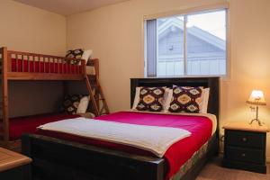 sypialnia z łóżkiem piętrowym i czerwoną narzutą w obiekcie Burfield Lodge, Ski In Ski Out with Hot Tub w mieście Sun Peaks