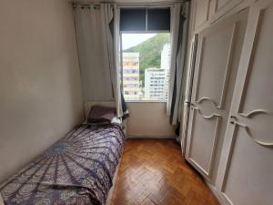 a small bedroom with a bed and a window at SuhcasaCopacabana 48 Spacious in Rio de Janeiro