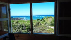 una ventana con vistas al océano en Chalets Chomoni 