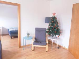 einen Weihnachtsbaum und einen Stuhl im Wohnzimmer in der Unterkunft Bad Homburg Wohnung für 5 Personen in Bad Homburg vor der Höhe