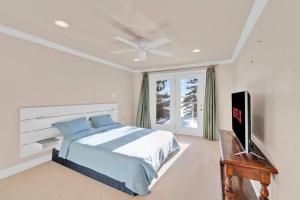 a bedroom with a bed and a flat screen tv at Stunning 4BR Cottage with Lake View in Barrie