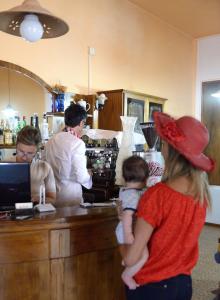 a woman and a child standing at a counter in a kitchen at Hotel Piccola Firenze in Firenzuola