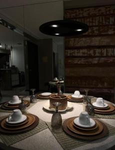 une table avec plaques et chapeaux en haut dans l'établissement Apartamento em Barra Bali, Resort de Luxo, Barra de São de Miguel - 223, à Barra de São Miguel