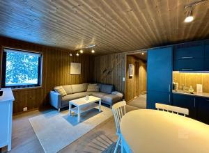 uma sala de estar com um sofá e uma mesa em Super apartment right on the slopes and stadium em Sjusjøen